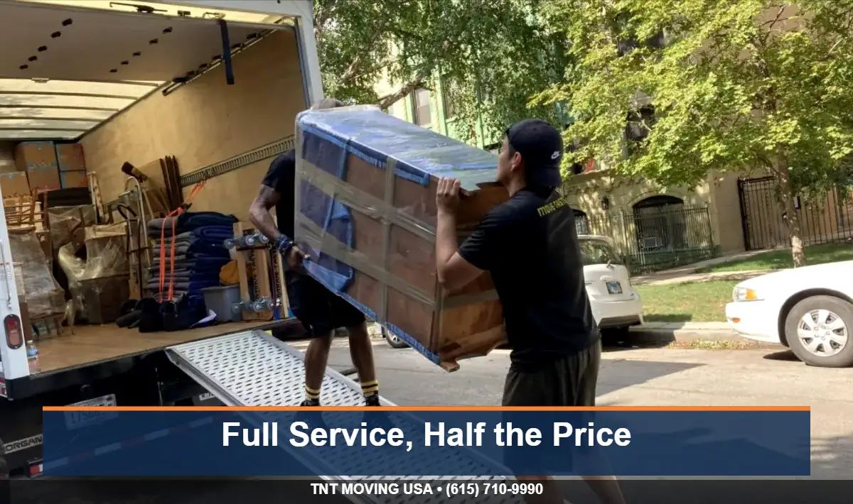 Movers wrapping furniture during a discounted Tennessee move