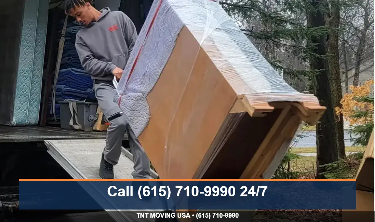 Mover protecting a doorway with door-jamb pads during a low income move in Tennessee